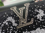 Louis Vuitton logo patch on black sequined handbag front with gold-toned trim