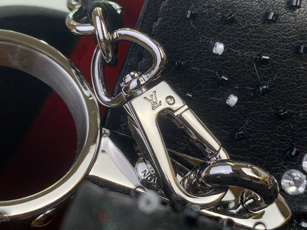 Louis Vuitton handbag hardware, silver clasp and D-ring on black leather