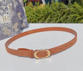 Tan leather belt with gold-tone oval buckle and adjustable holes