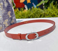 Red leather belt with silver oval buckle and adjustment holes