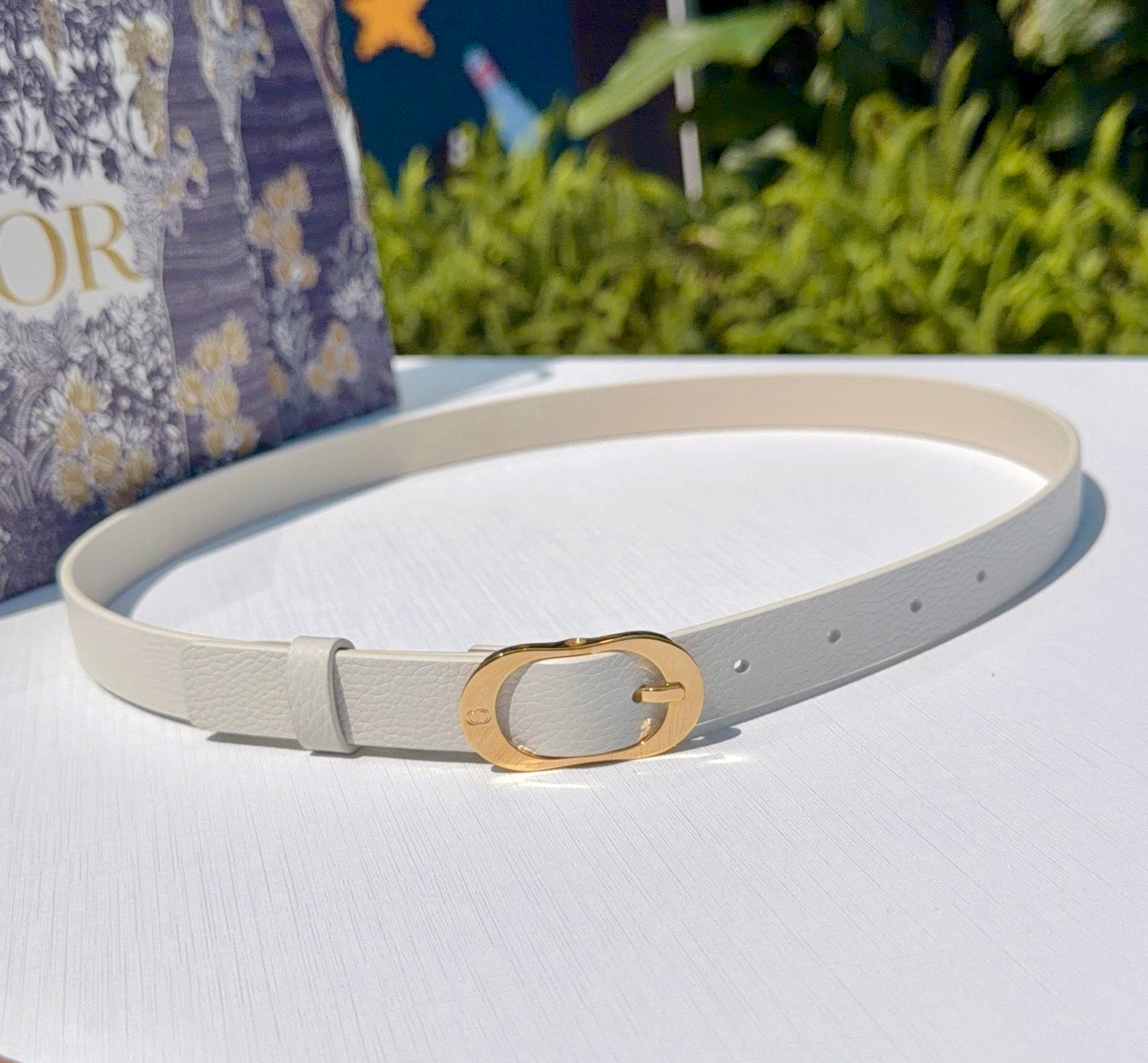 Dior belt with light gray leather strap and gold-tone oval buckle