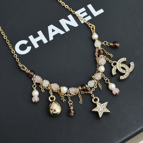 Gold-tone charm necklace with star, pearl drops, and multicolor bead dangles
