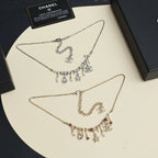 Two layered charm necklaces: silver-tone with star dangles and gold-tone with charms