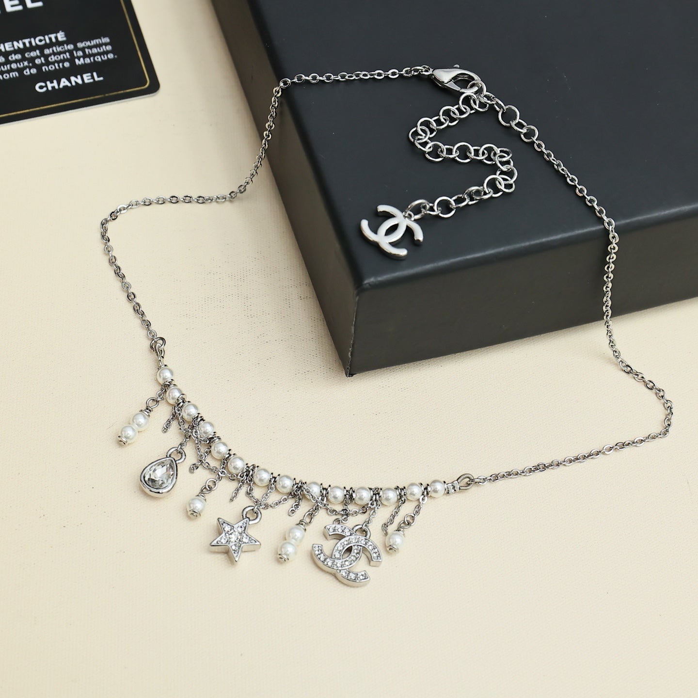 Silver-tone charm necklace with logo pendant, pearl and star dangles