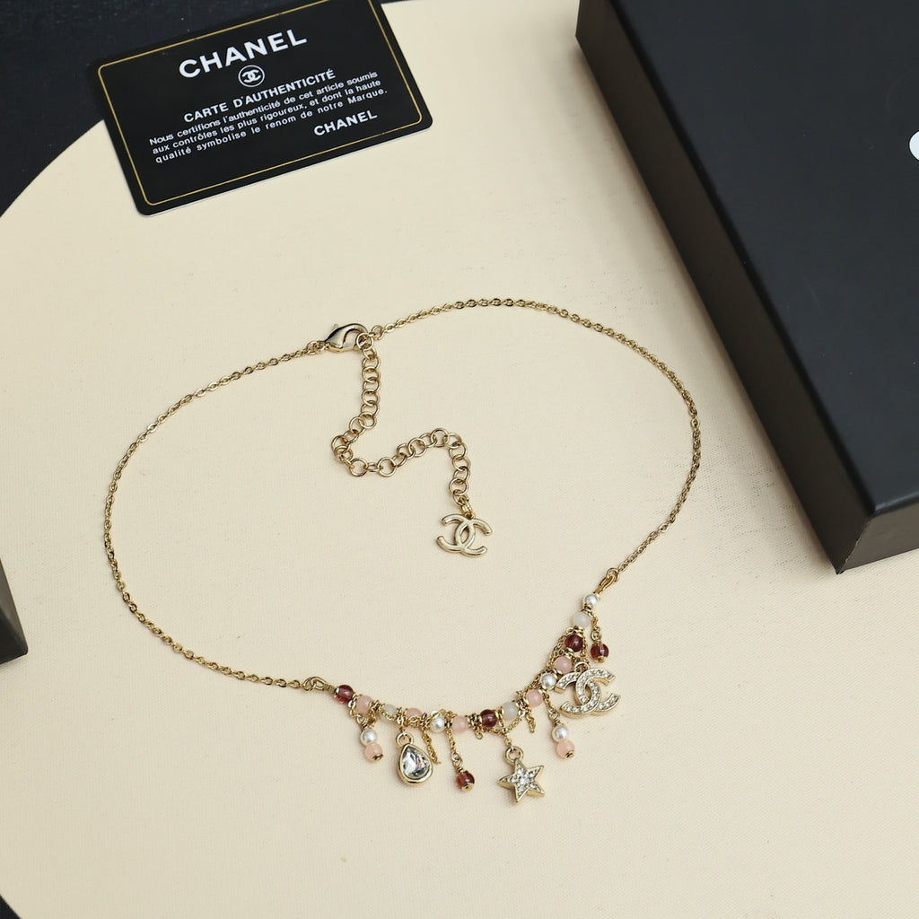 Gold-tone charm necklace with small logo pendant and dangling star and pearl charms