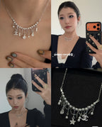 Silver-tone charm necklace with star and pearl drops, close-up on model