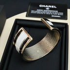 Two-tone cuff bracelets in a black gift box, gold and silver CHANEL accents