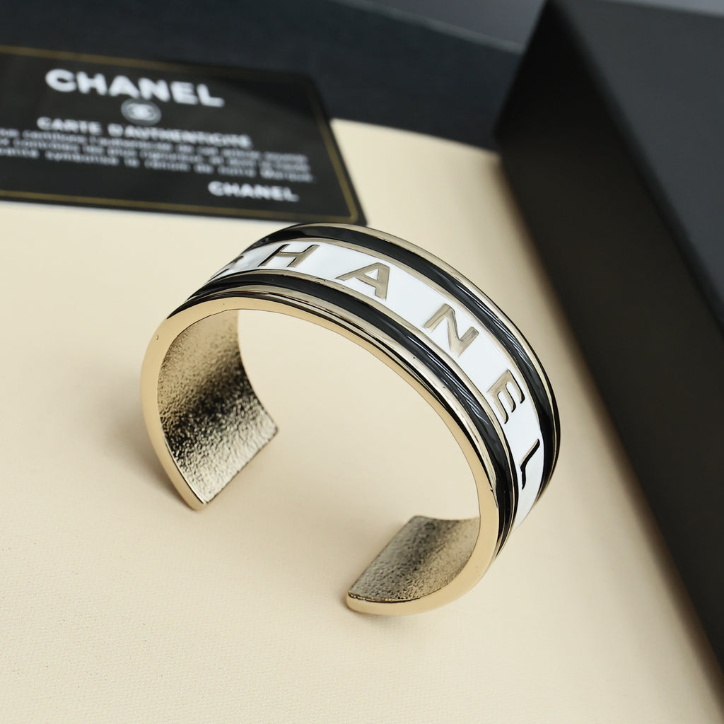 Gold-tone cuff bracelet with CHANEL engraved letters in a close-up