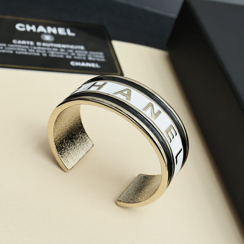 Gold-tone cuff bracelet with CHANEL engraved letters in a close-up