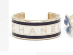 Navy-and-gold cuff bracelet with CHANEL letters on a white enamel band