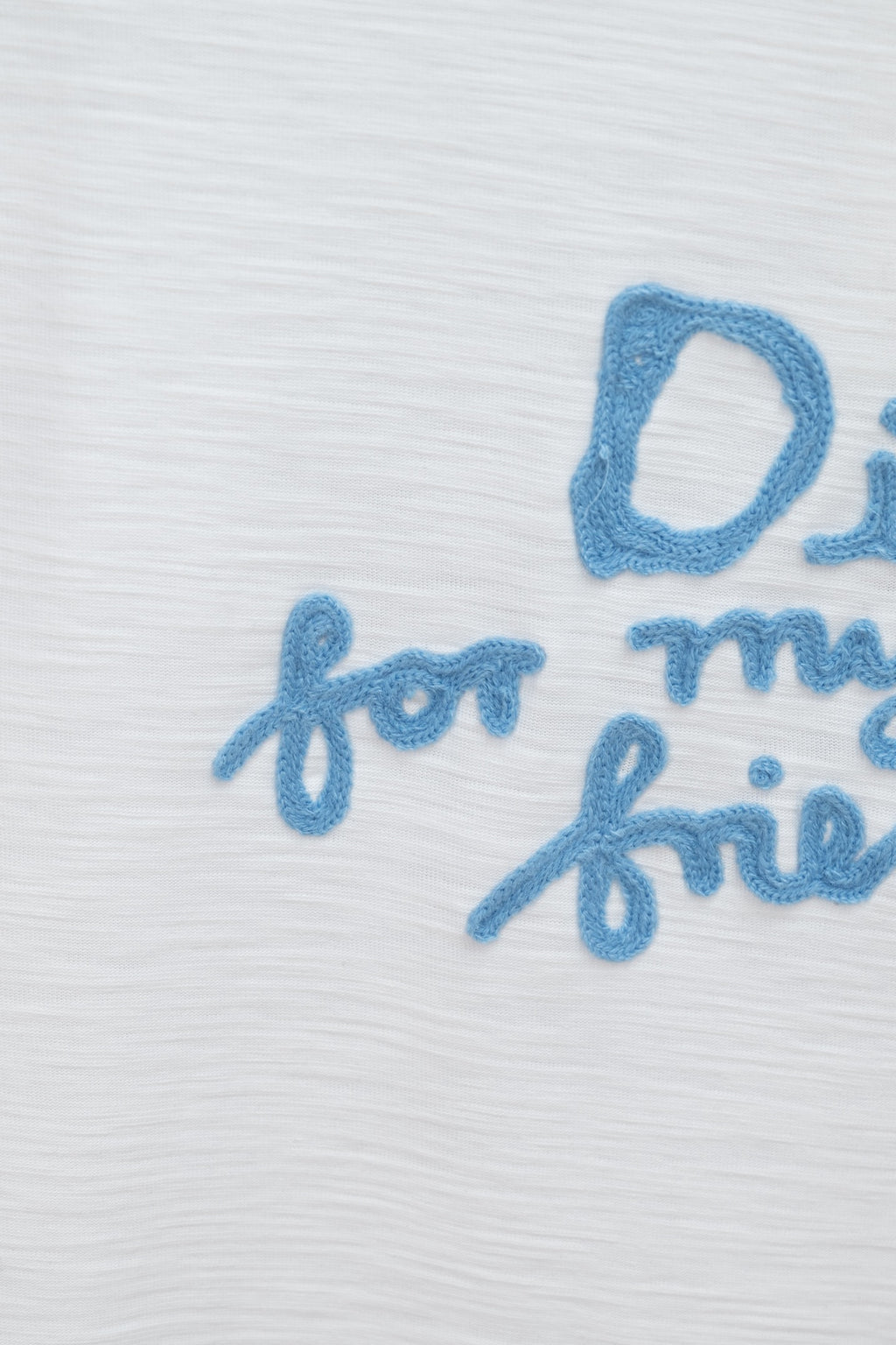 White T-shirt close-up of blue embroidered 'for my real' text