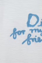 White T-shirt close-up of blue embroidered 'for my real' text
