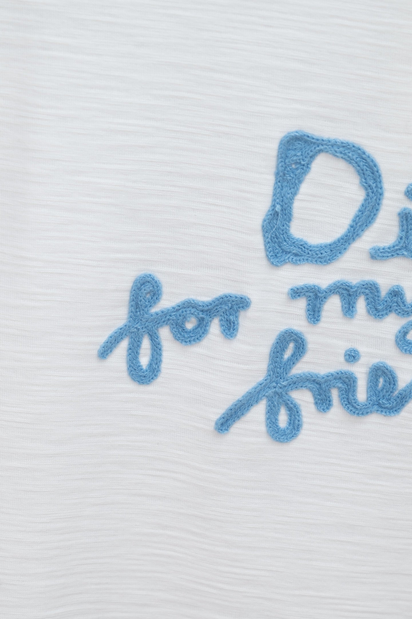 White T-shirt close-up of blue embroidered 'for my real' text