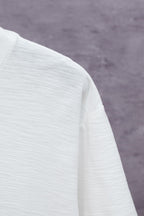 White short-sleeve T-shirt fabric close-up at shoulder and side seam