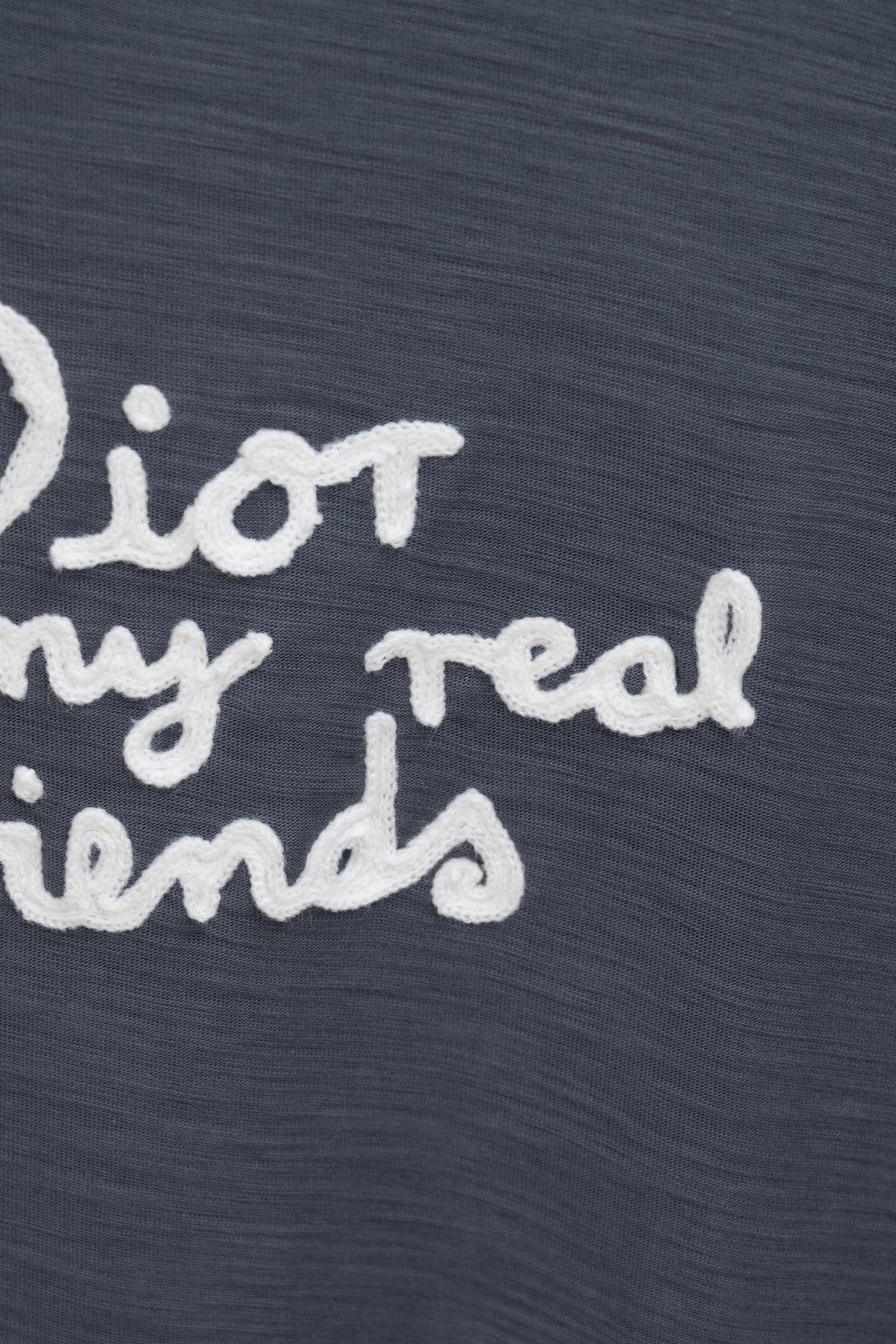 Dark blue T-shirt close-up showing partial white slogan text