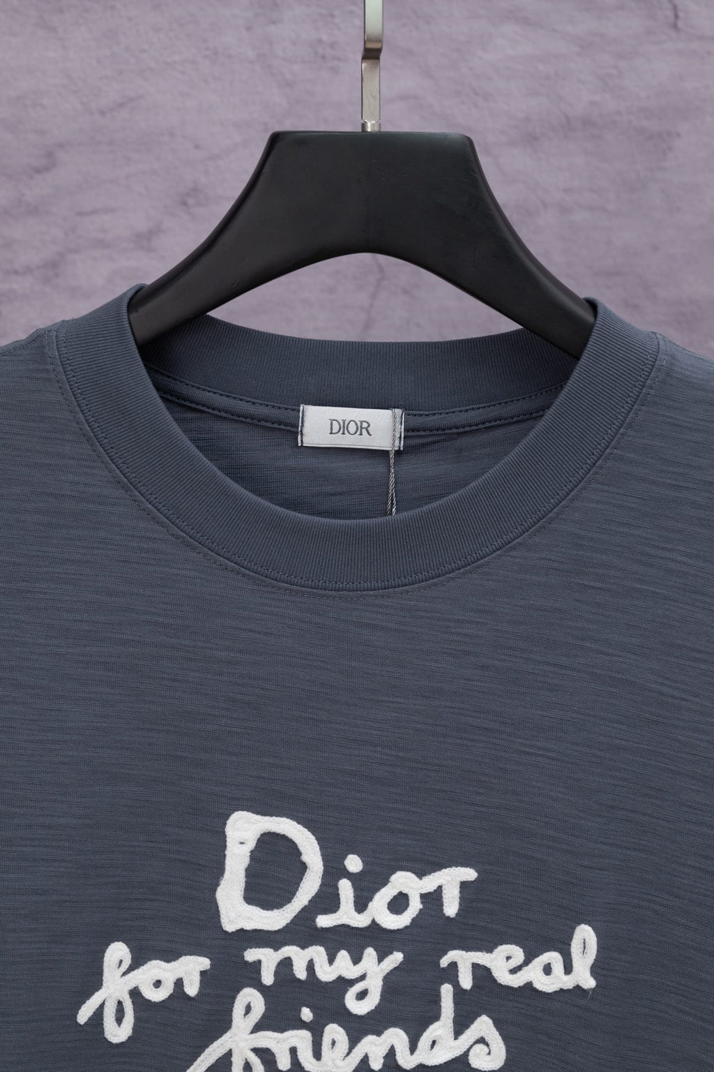 Dark blue crewneck T-shirt close-up with white slogan print at chest