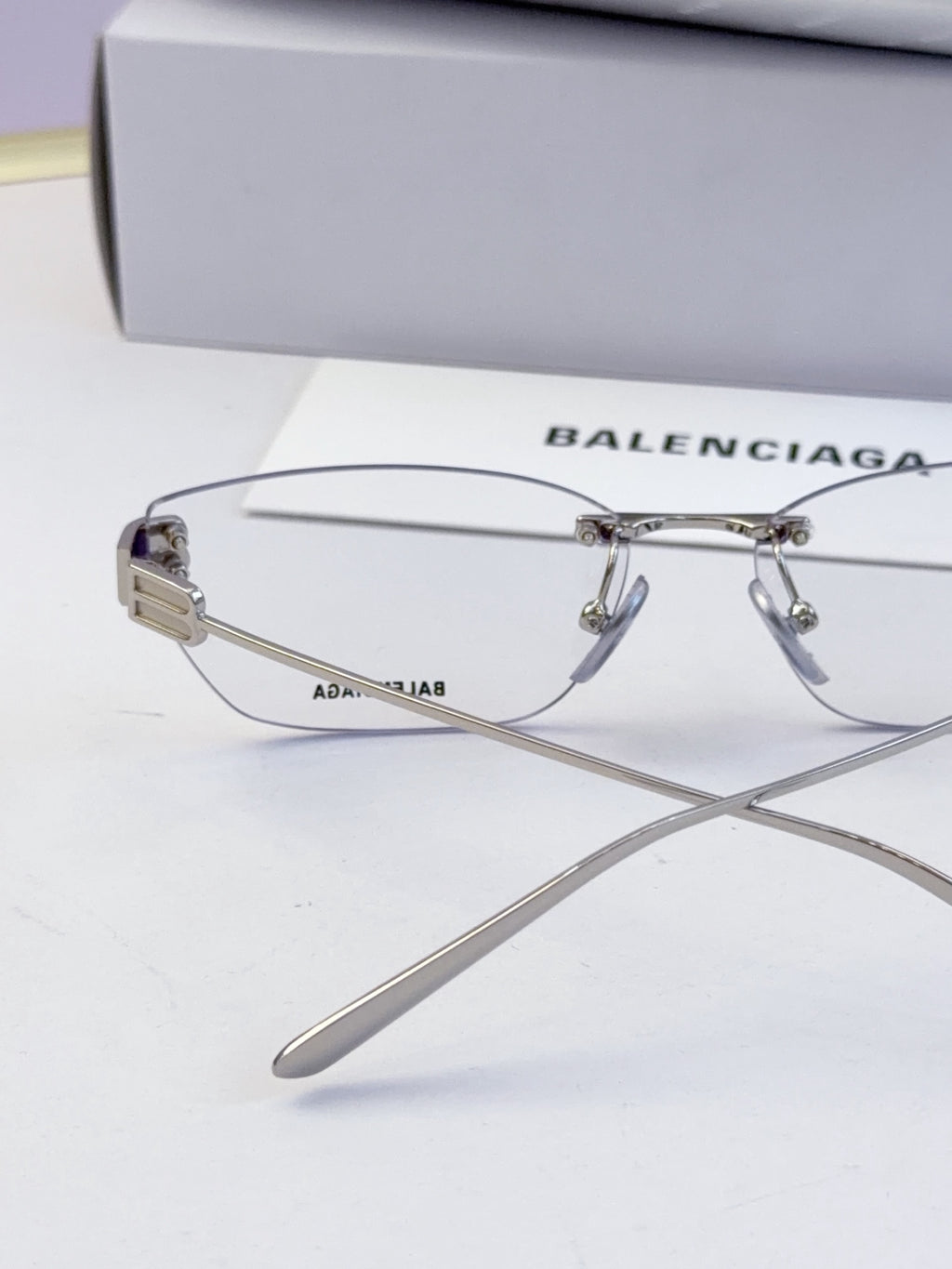 Balenciaga eyeglasses side view with clear lenses and engraved metal temples