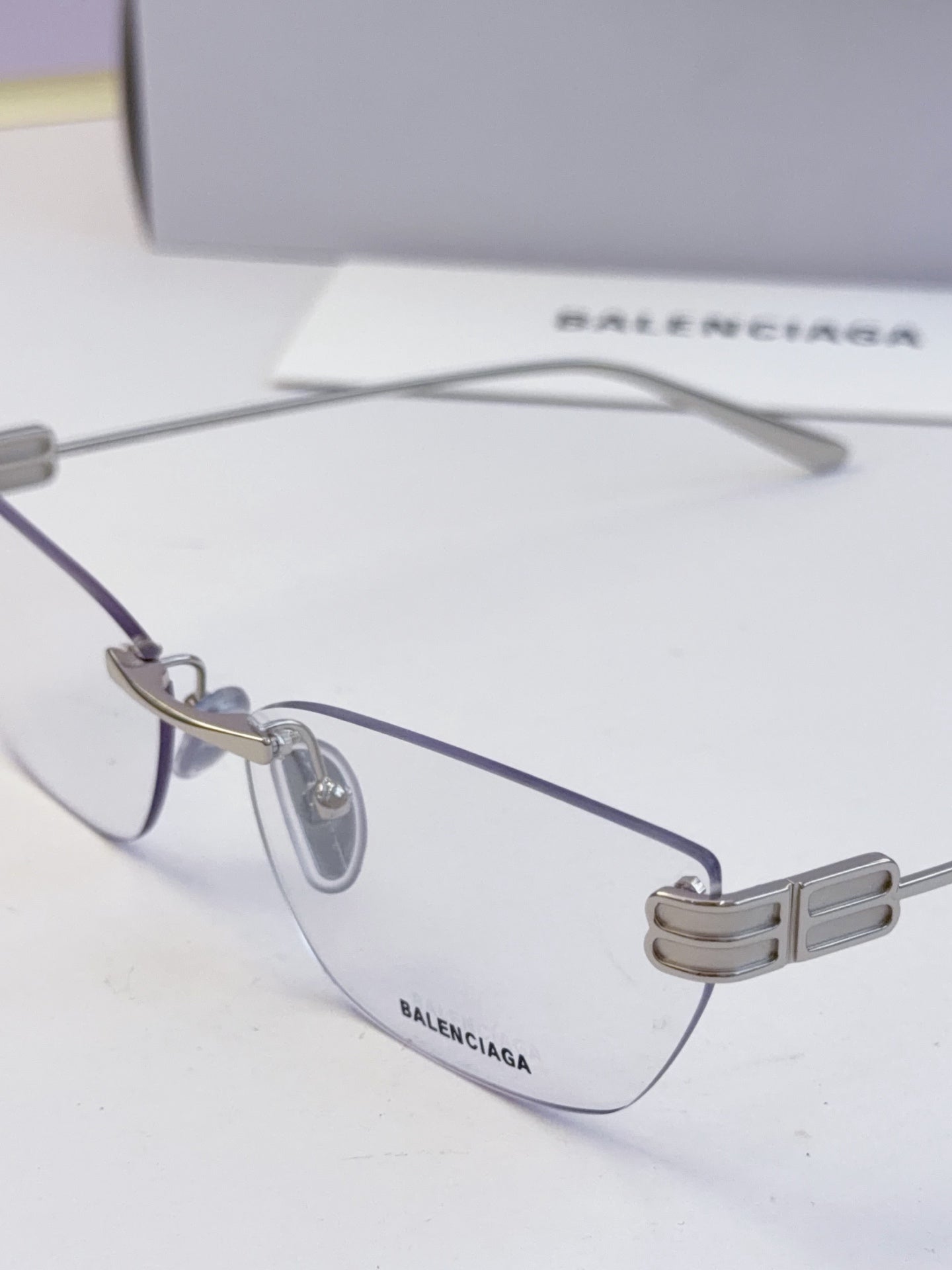 Balenciaga eyeglasses close-up: clear lenses and ribbed metal temple detail