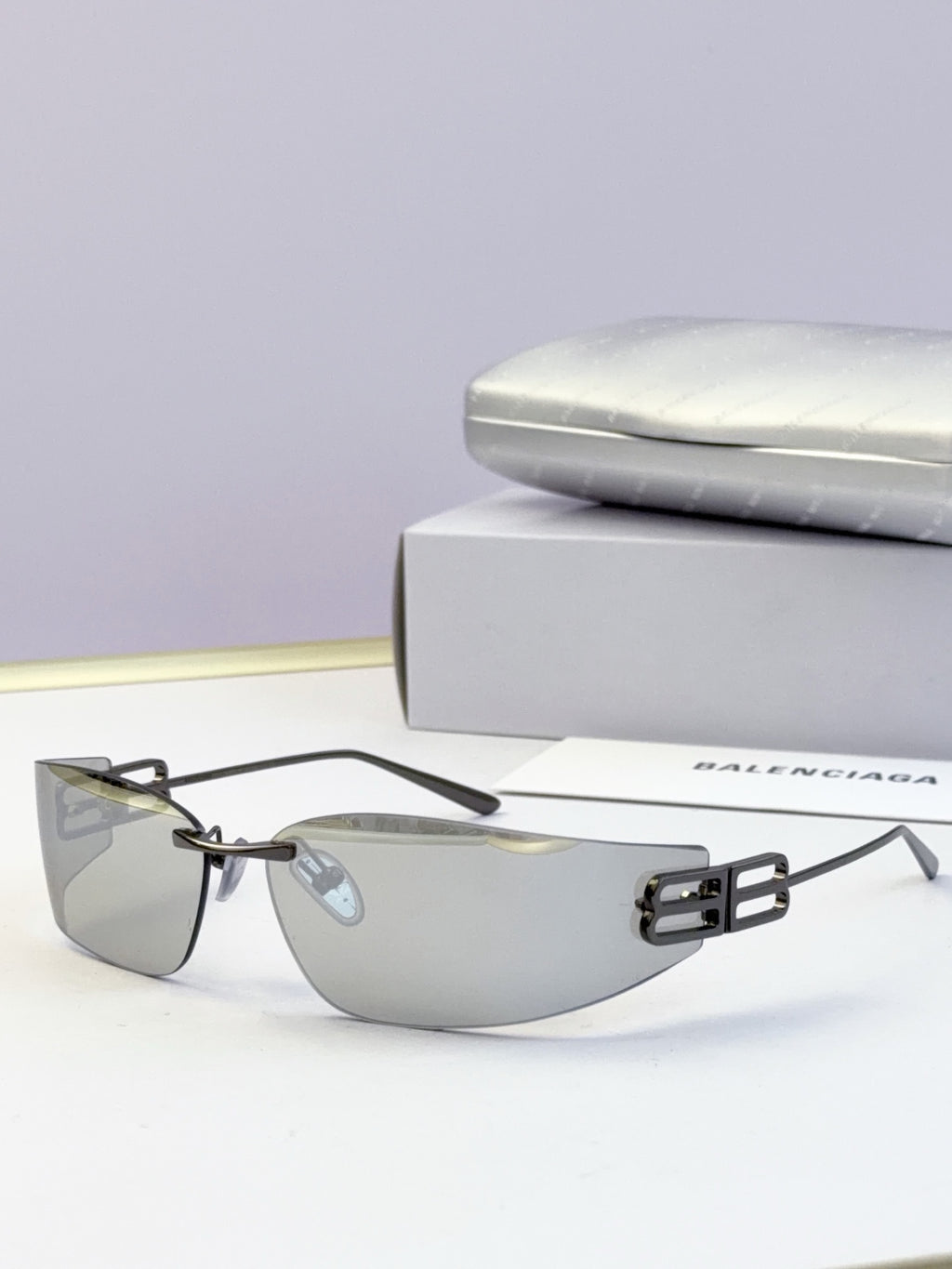 Balenciaga sunglasses with black frame accents and gray tinted lenses, logo bar detail