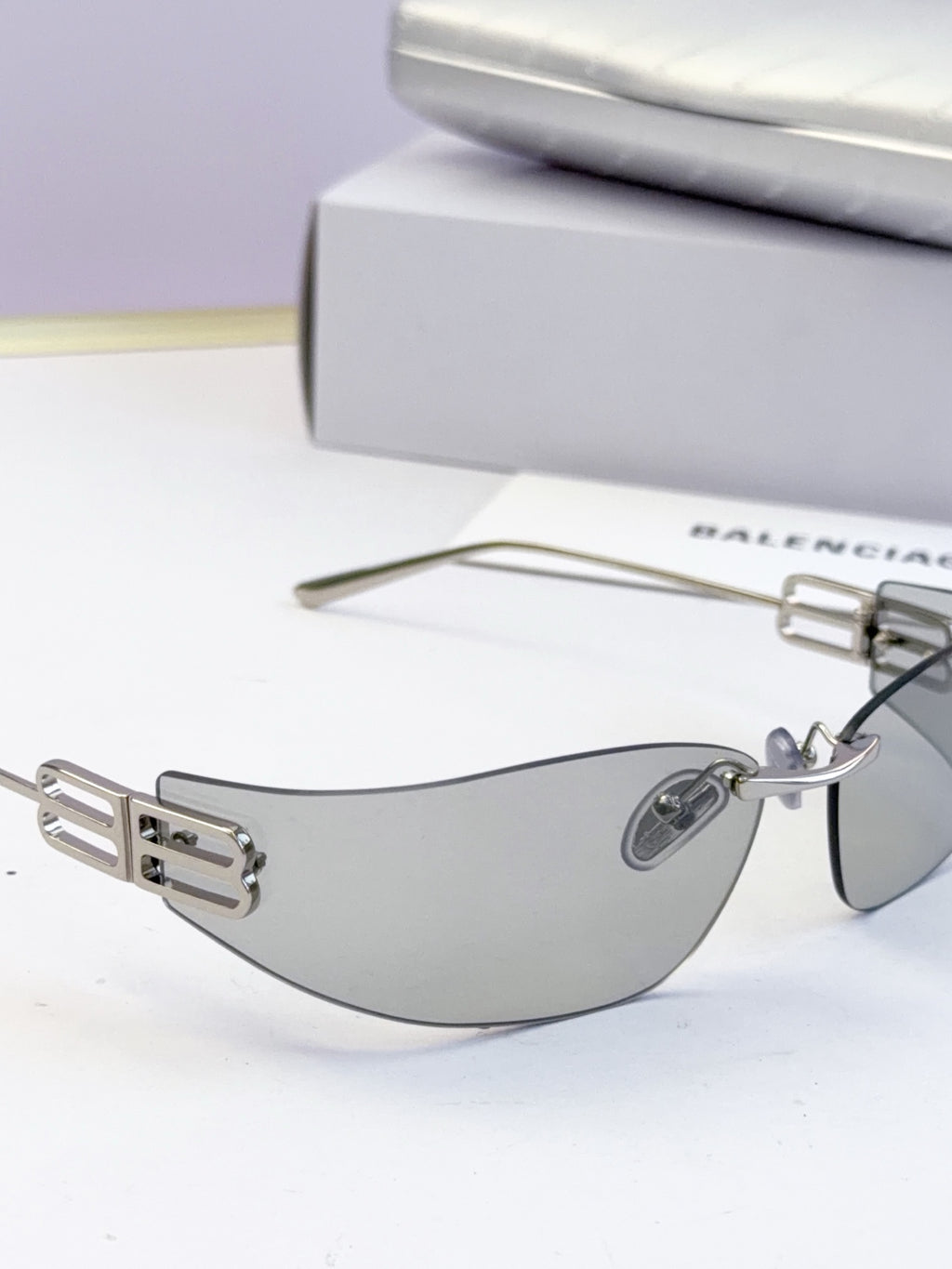 Balenciaga sunglasses shown from the side with gray tinted lenses and gold logo detail