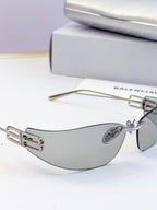 Balenciaga sunglasses shown from the side with gray tinted lenses and gold logo detail