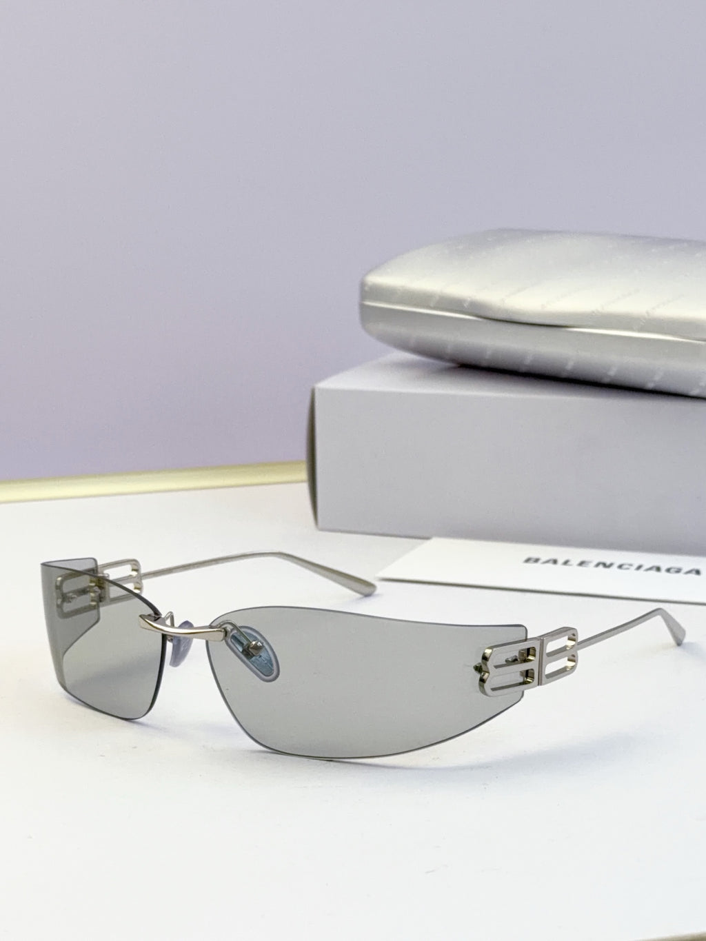 Balenciaga sunglasses with gold frame and gray tinted lenses, logo bar detail