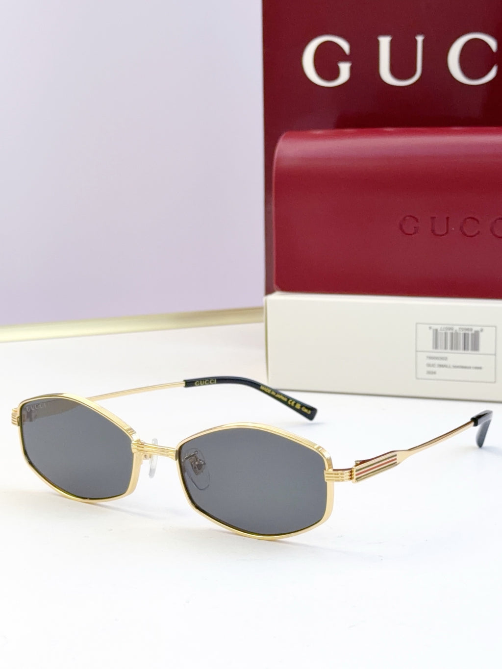 Gold full-rim glasses with dark tinted lenses and ribbed metal temple arms