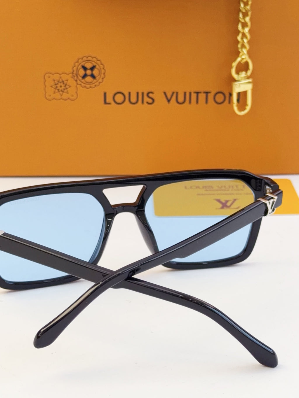 Louis Vuitton square sunglasses close-up with blue lenses and logo on temple