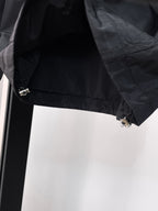 Long jacket lower sleeve detail in dark gray with snap and metal zipper hardware