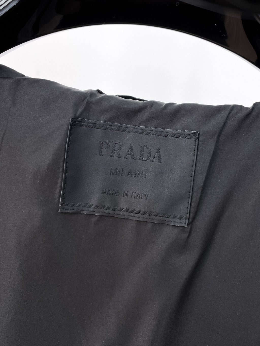 Long jacket interior fabric label with PRADA text in dark gray
