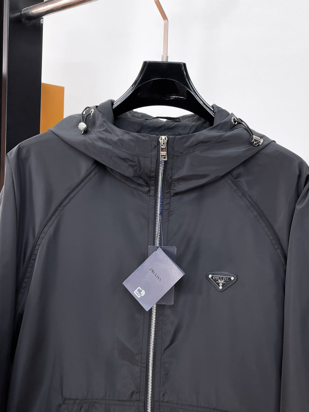 Long hooded zip jacket chest detail in dark gray with center zipper and logo patch