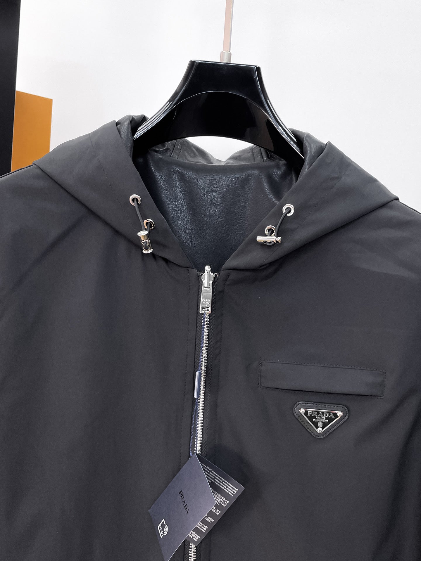 Dark hooded zip jacket chest logo patch with front zipper and hang tag