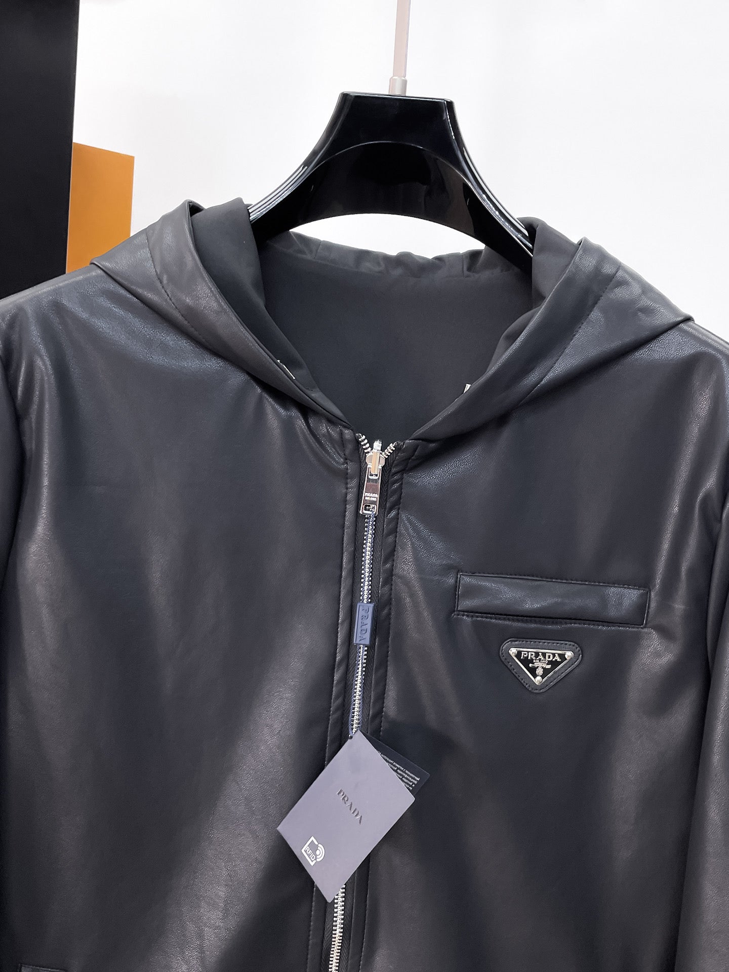 Dark hooded zip jacket with Prada chest logo patch and front zipper
