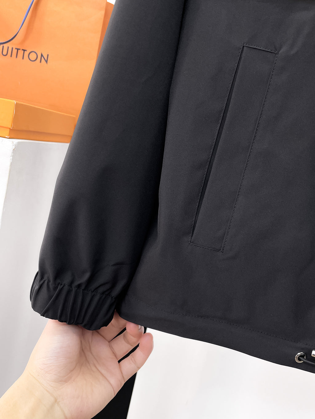 Dark jacket sleeve cuff with elastic hem and side pocket seam