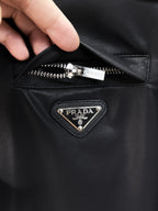 Dark jacket front zipper and Prada triangle logo on chest pocket