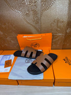 Brown and black Hermes-style slide sandals with three wide strap bands