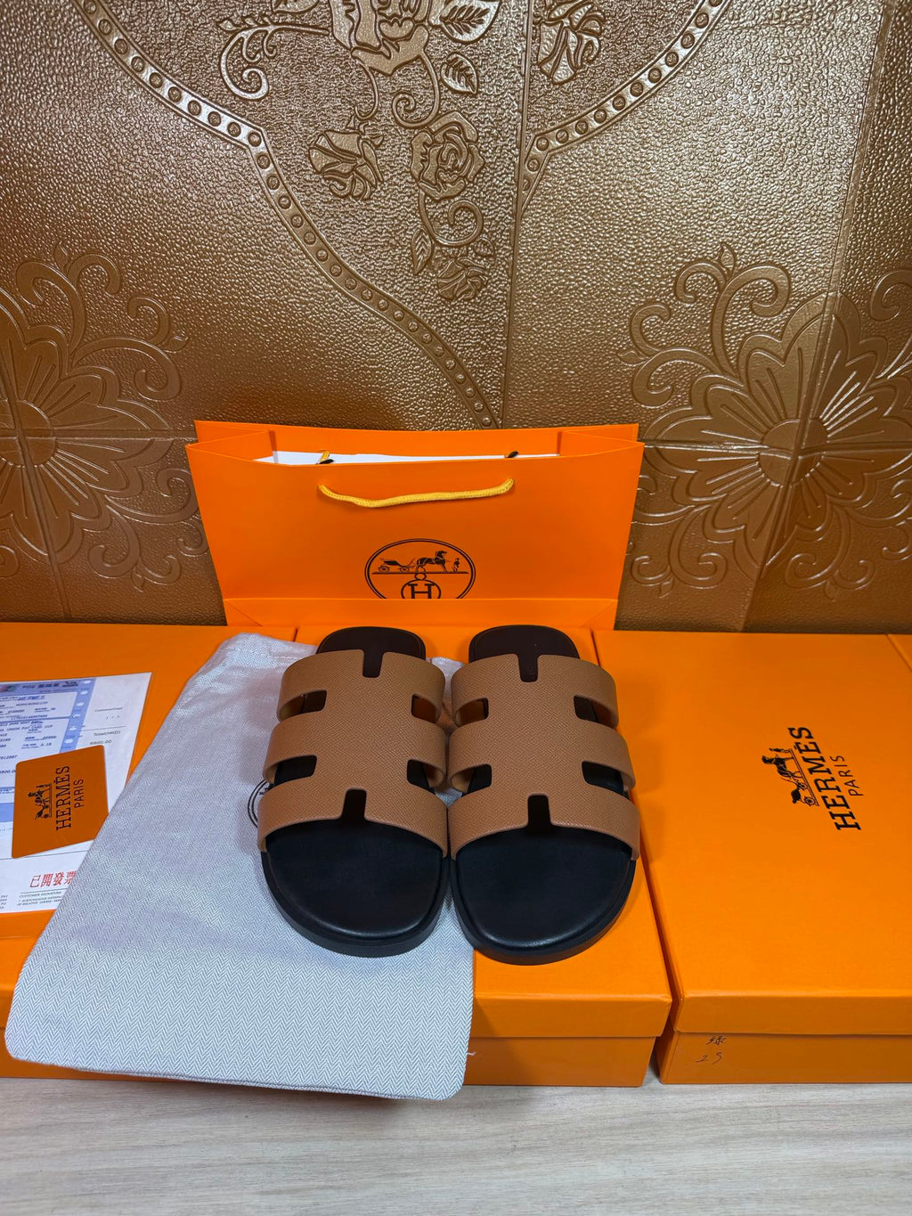 Brown and black slide sandals on display with wide strap bands and dark soles