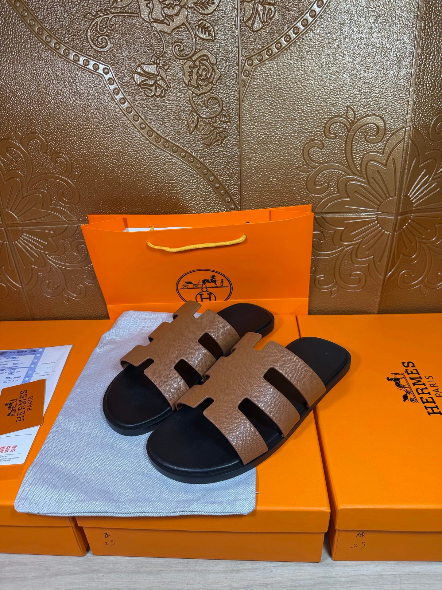 Brown leather slide sandals with wide strap bands and dark molded footbeds