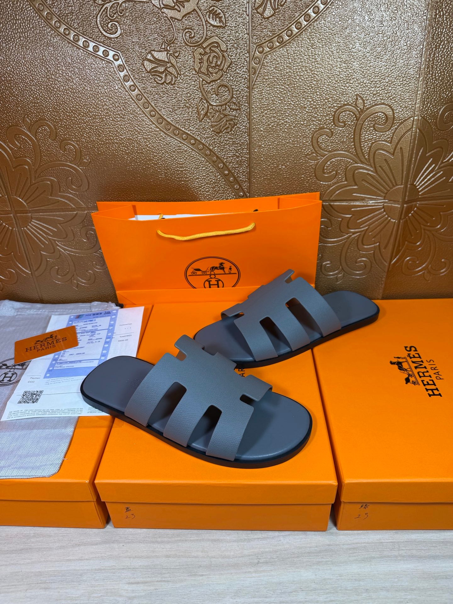 Two Hermes slide sandals in dark blue with wide cutout straps and open toe