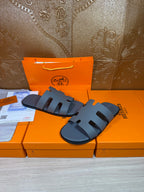 Hermes slide sandals in dark blue, side view of wide straps with open toe