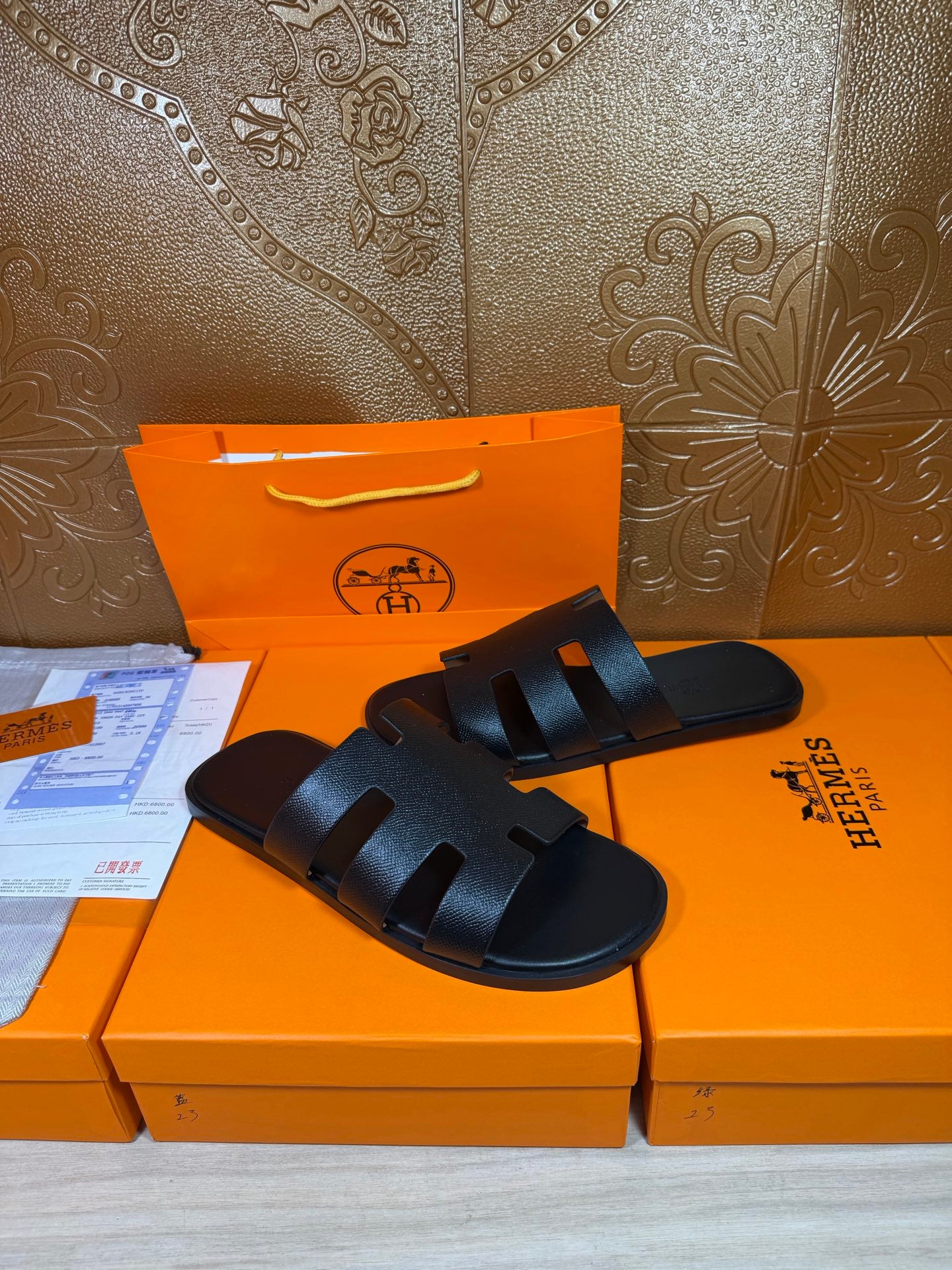 Black slide sandals with wide band straps across the top and open toe