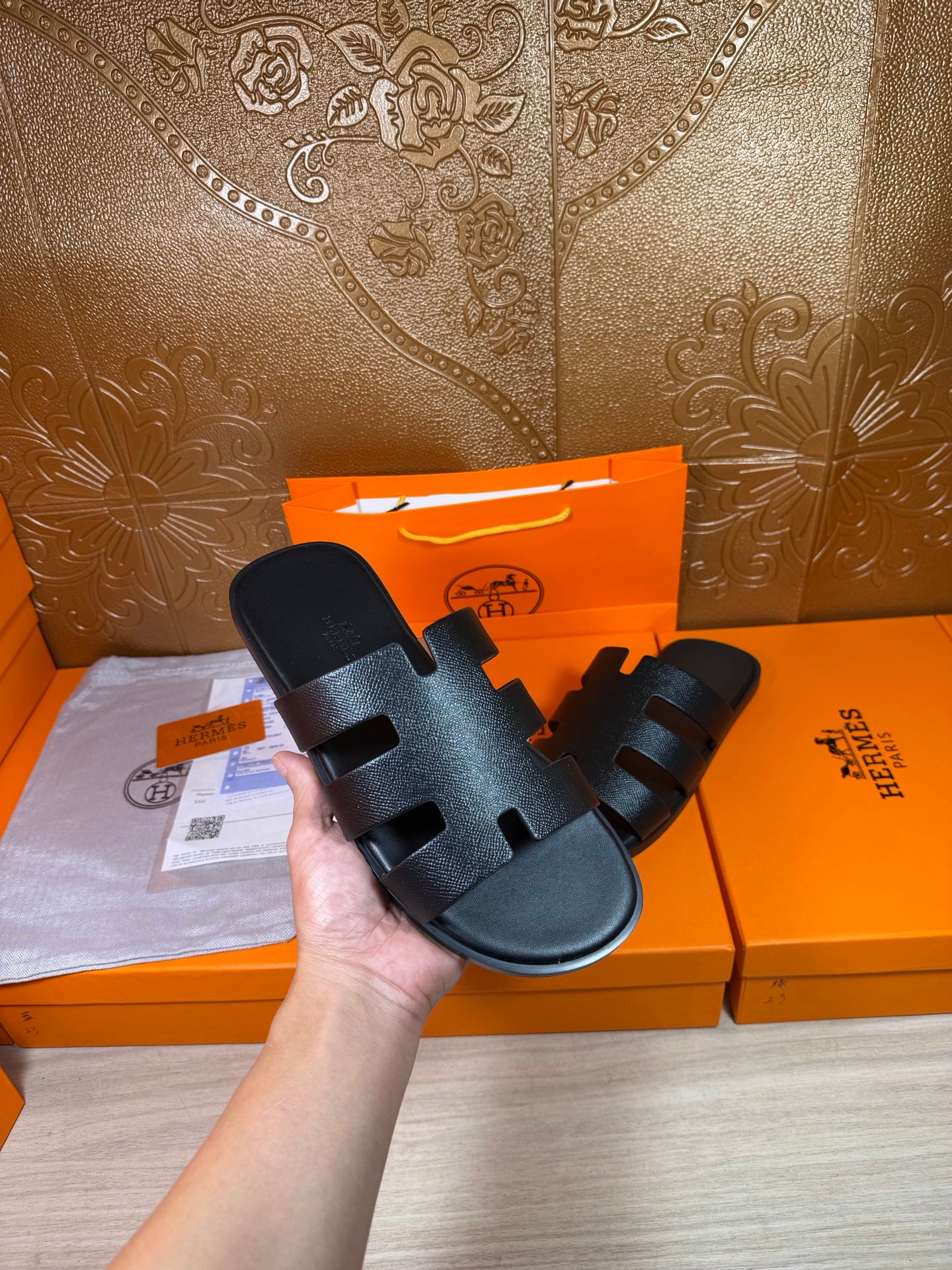 Black slide sandals with wide straps and open toe, held by the side strap