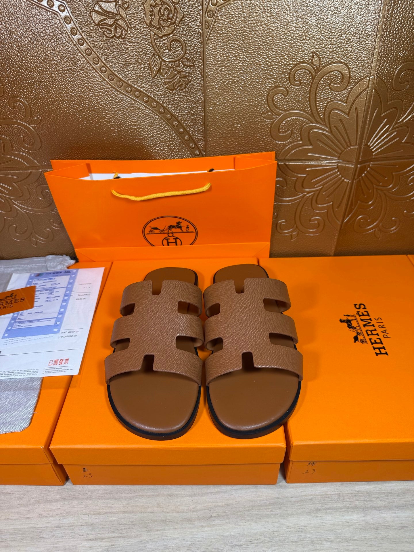 Brown slide sandals with wide cutout straps and textured footbed, closed toe style.