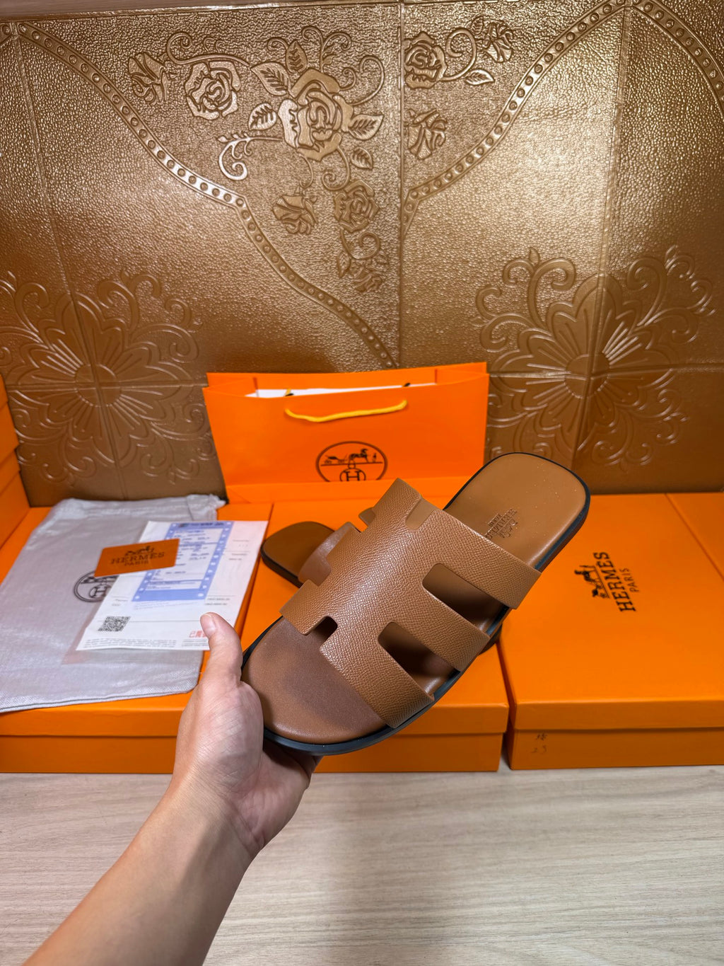 Brown slide sandals with three wide cutout straps, flat sole, and molded footbed.