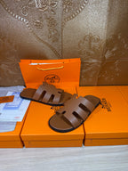 Brown slide sandals with three wide cutout straps and dark molded sole, flat fit.