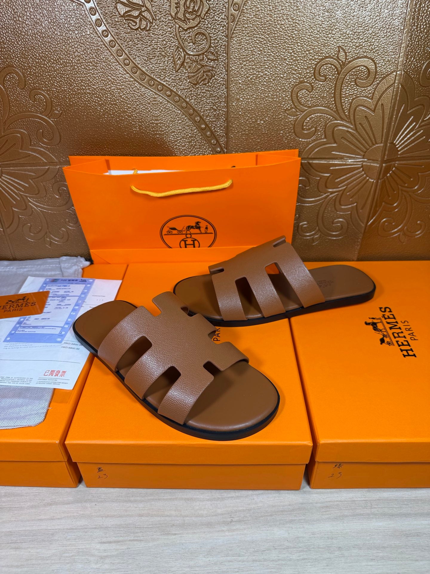 Brown slide sandals with wide cutout straps, flat outsole, and smooth leather footbed.