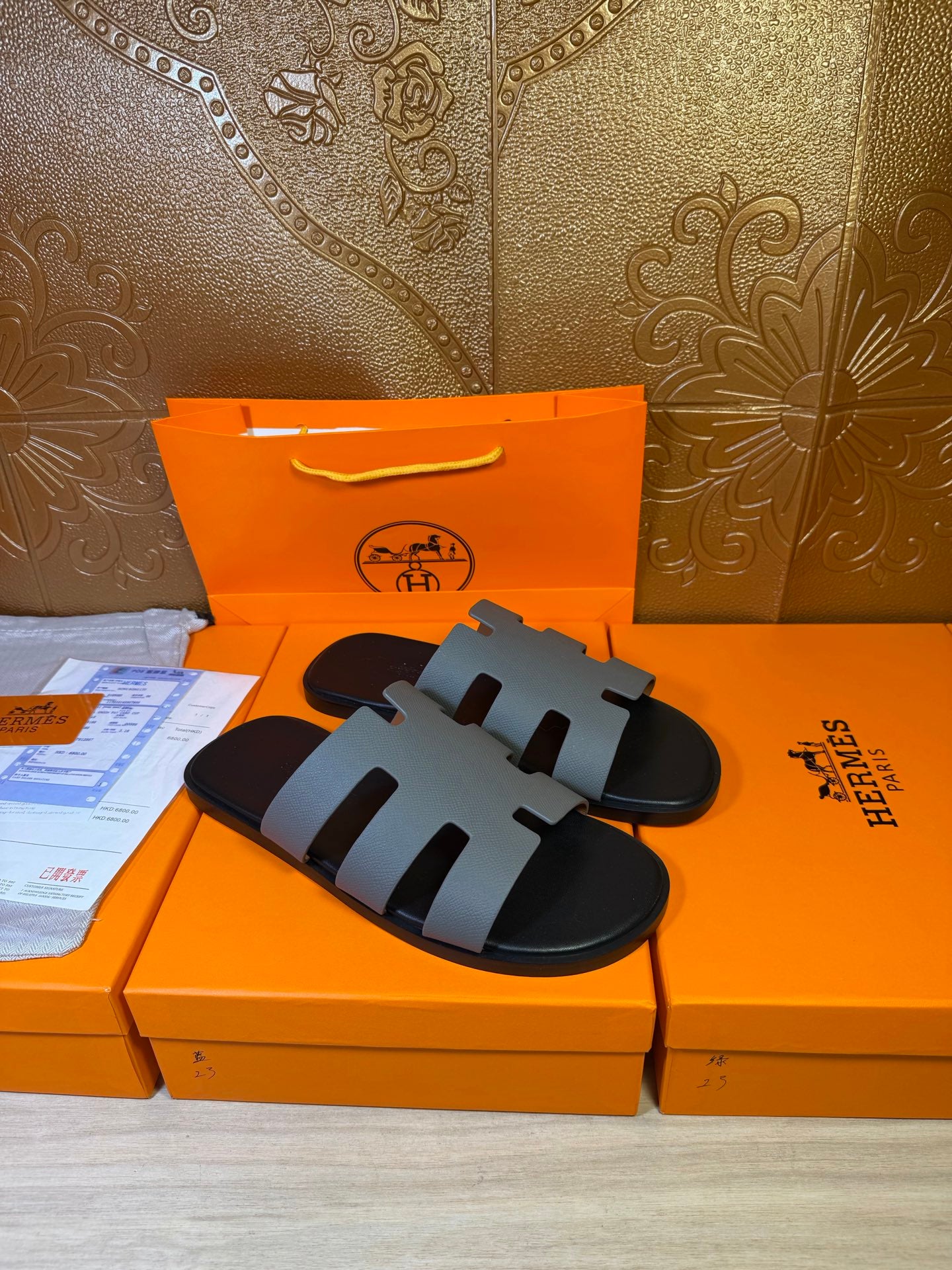 Hermes slide sandals on display, black footbed with light gray straps
