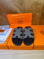 Hermes sandals with black footbed and light gray striped straps
