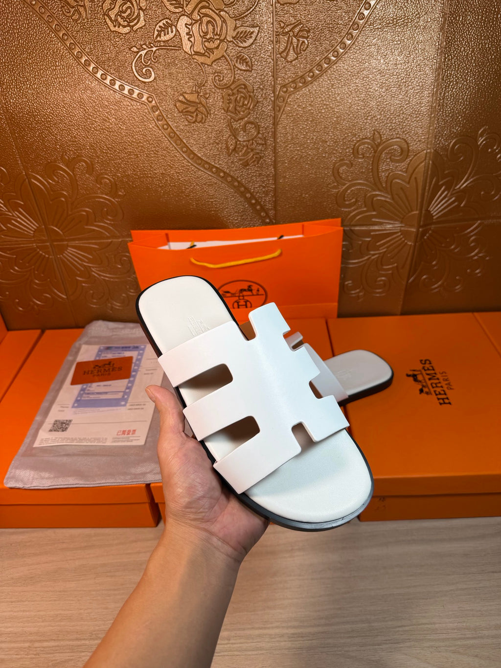 Hermes sandals held up: white multi-strap slide sandals, open toe