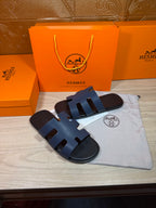 Hermes open-toe slide sandals, dark blue leather with three wide strap panels and H logo sole.